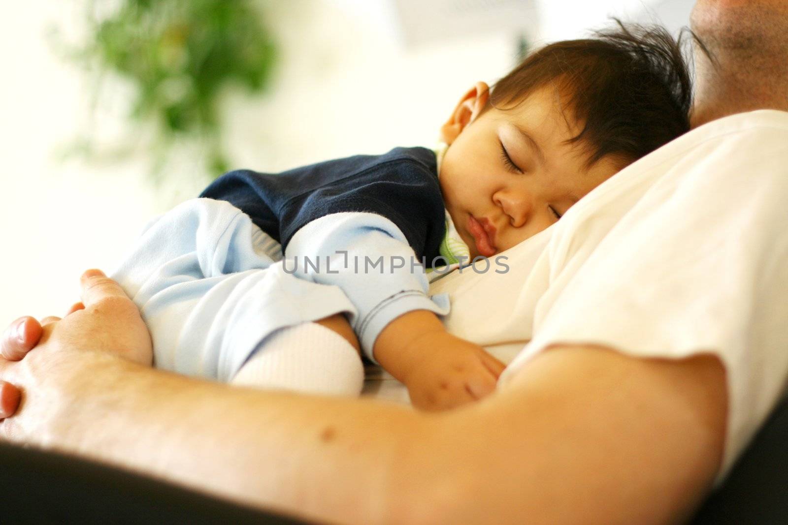 Baby asleep on his father's chest.