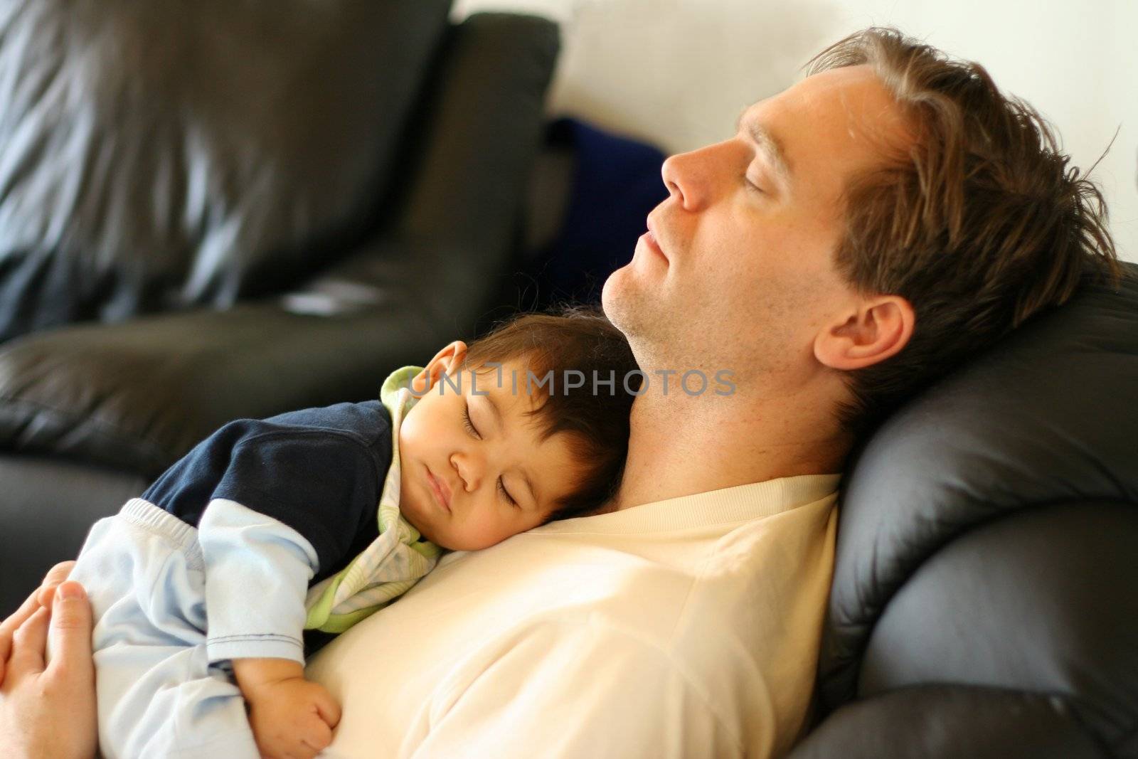 Baby asleep on his father's chest.