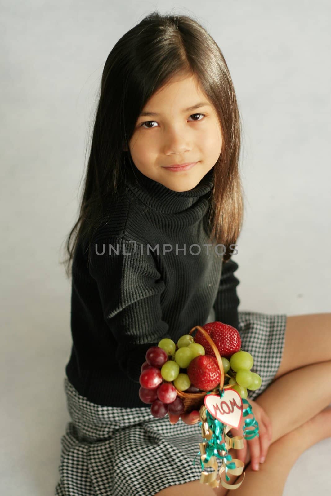 Little girl with a small fruit basket for mom