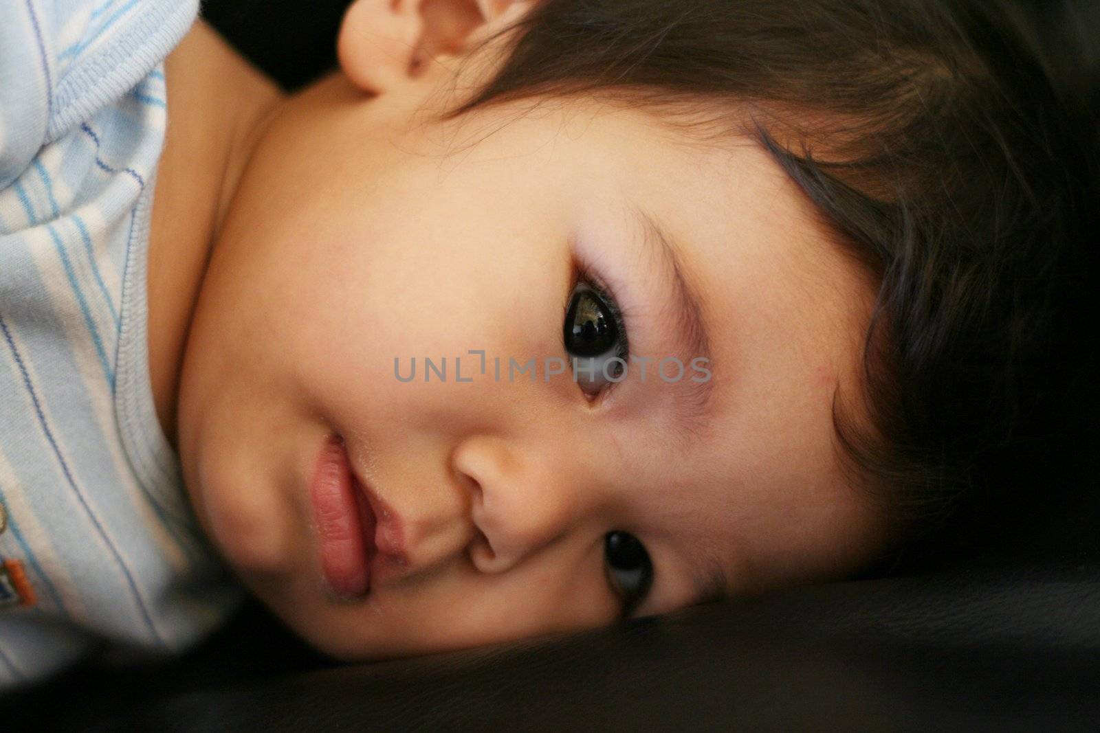 Baby boy quietly lying on couch