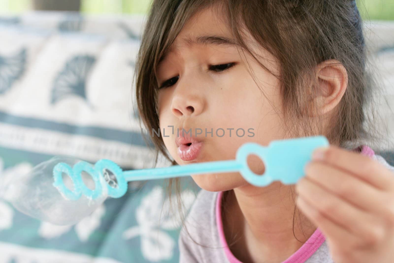 Child blowing bubbles outdoors