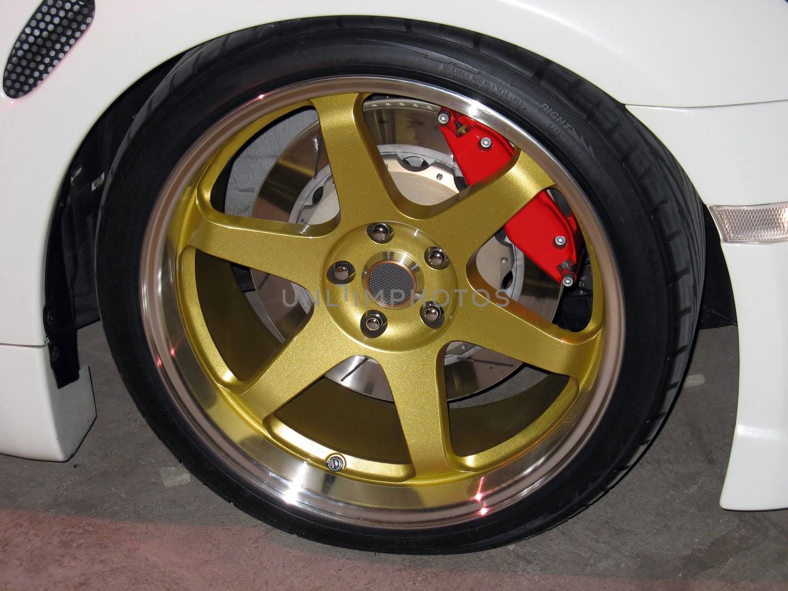 custom gold rims on a white sportscar complete with performance brakes