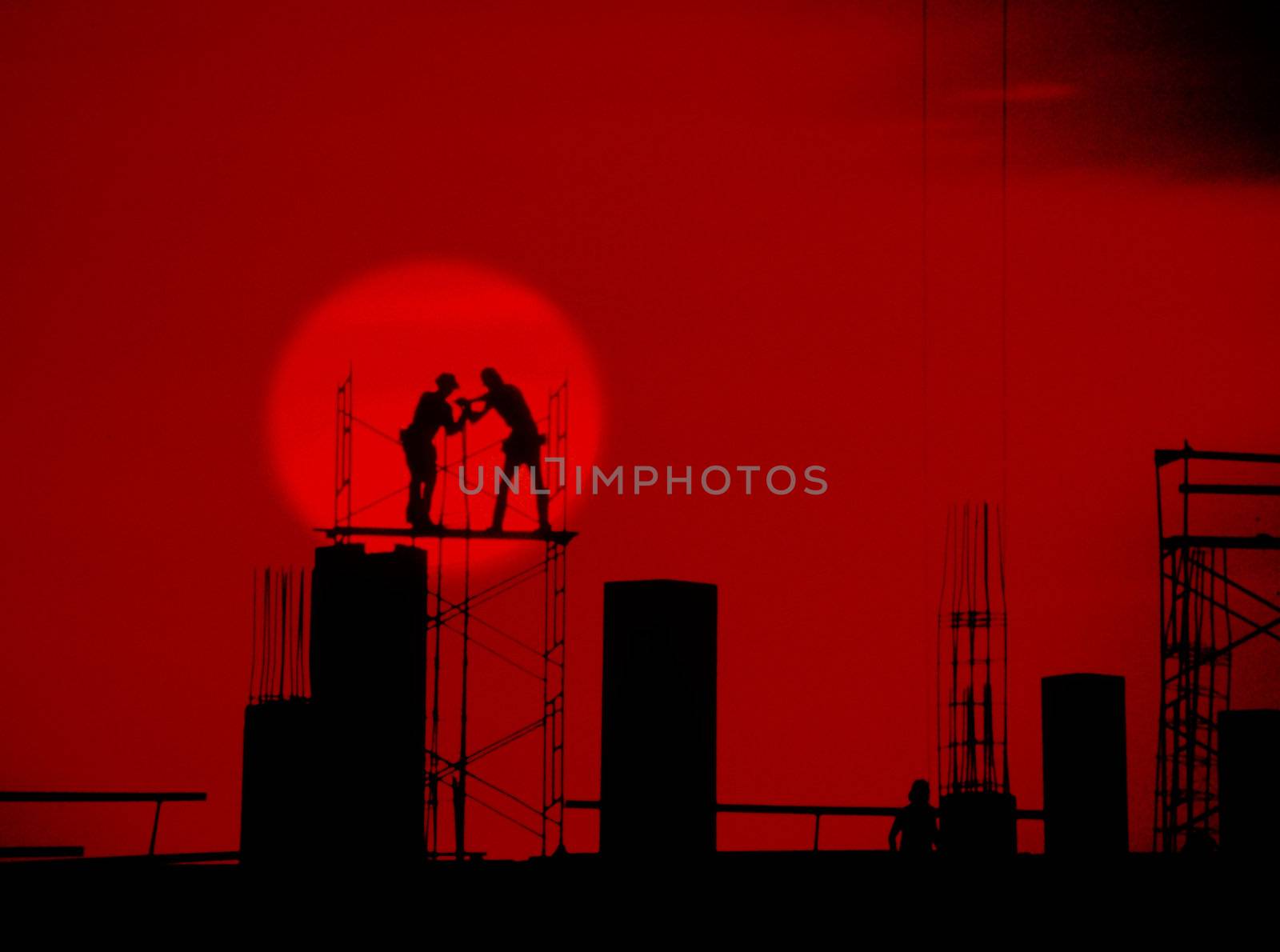 silhouette of men on scaffolding red