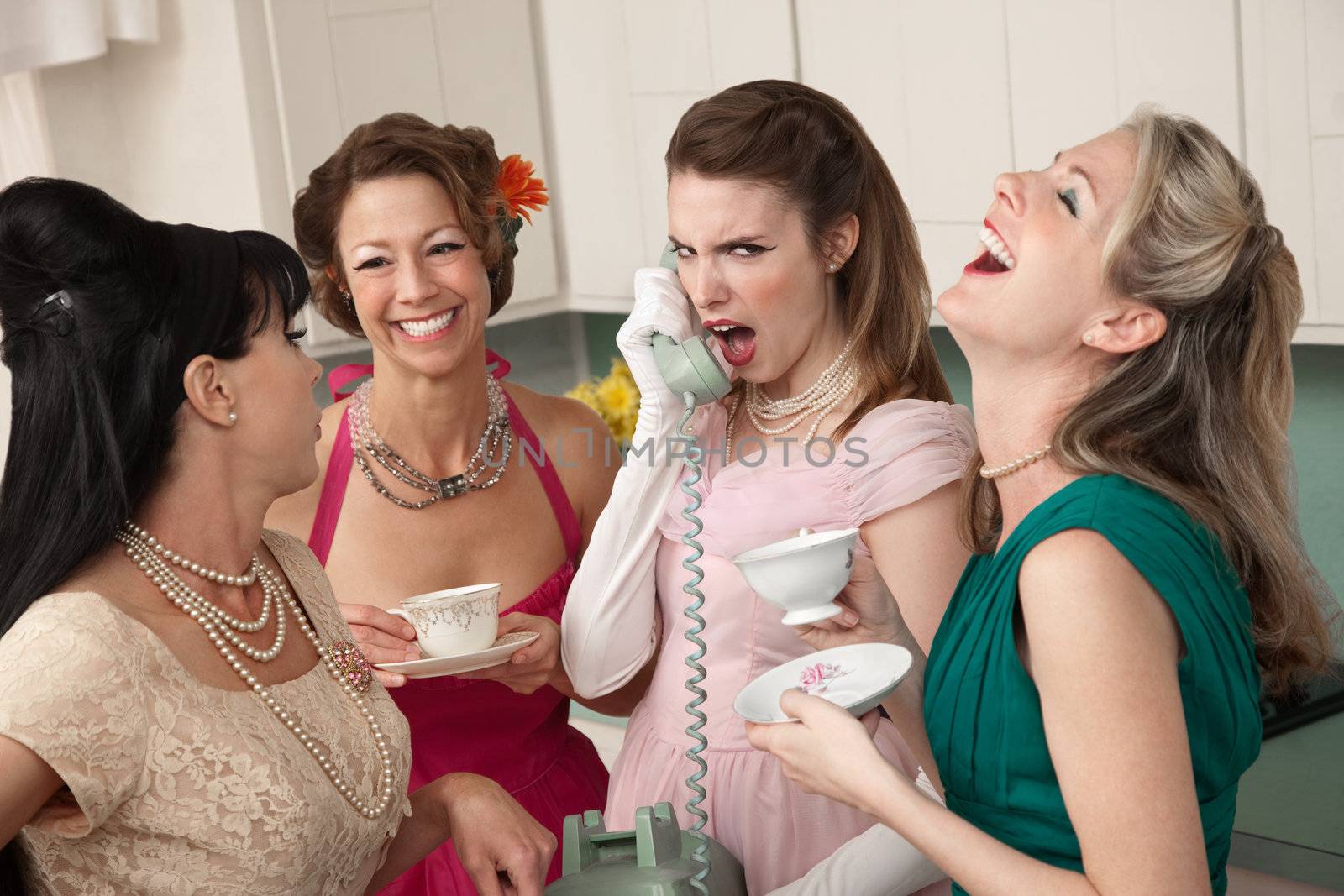 Outraged woman on phone with three friends in a kitchen
