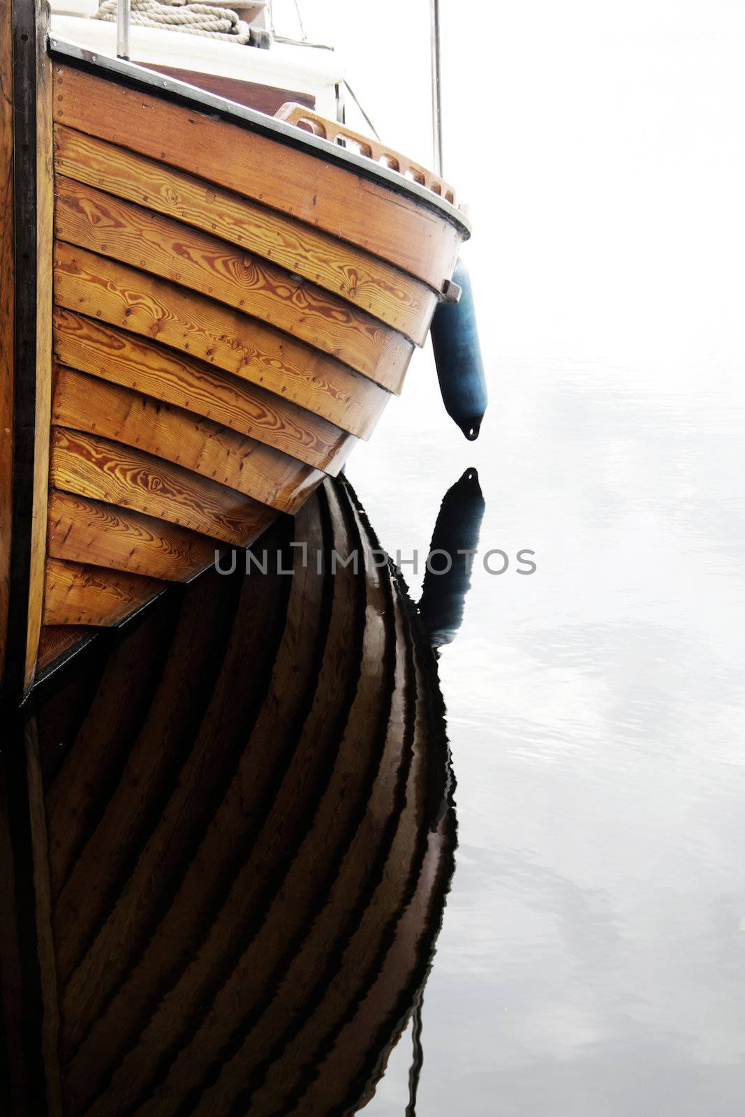 A closeup of a wooden boat, reflection in the lake
