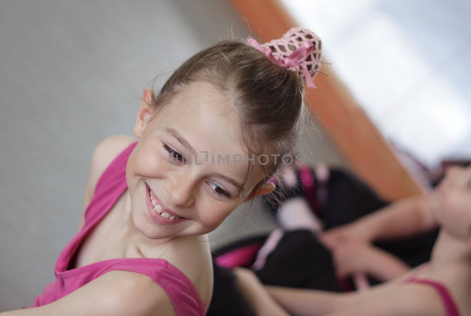 Young girl laughing with her friends during her ballet lesson