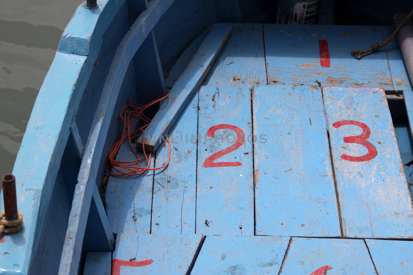 Close up of a wooden boat with painted numbers on the decking