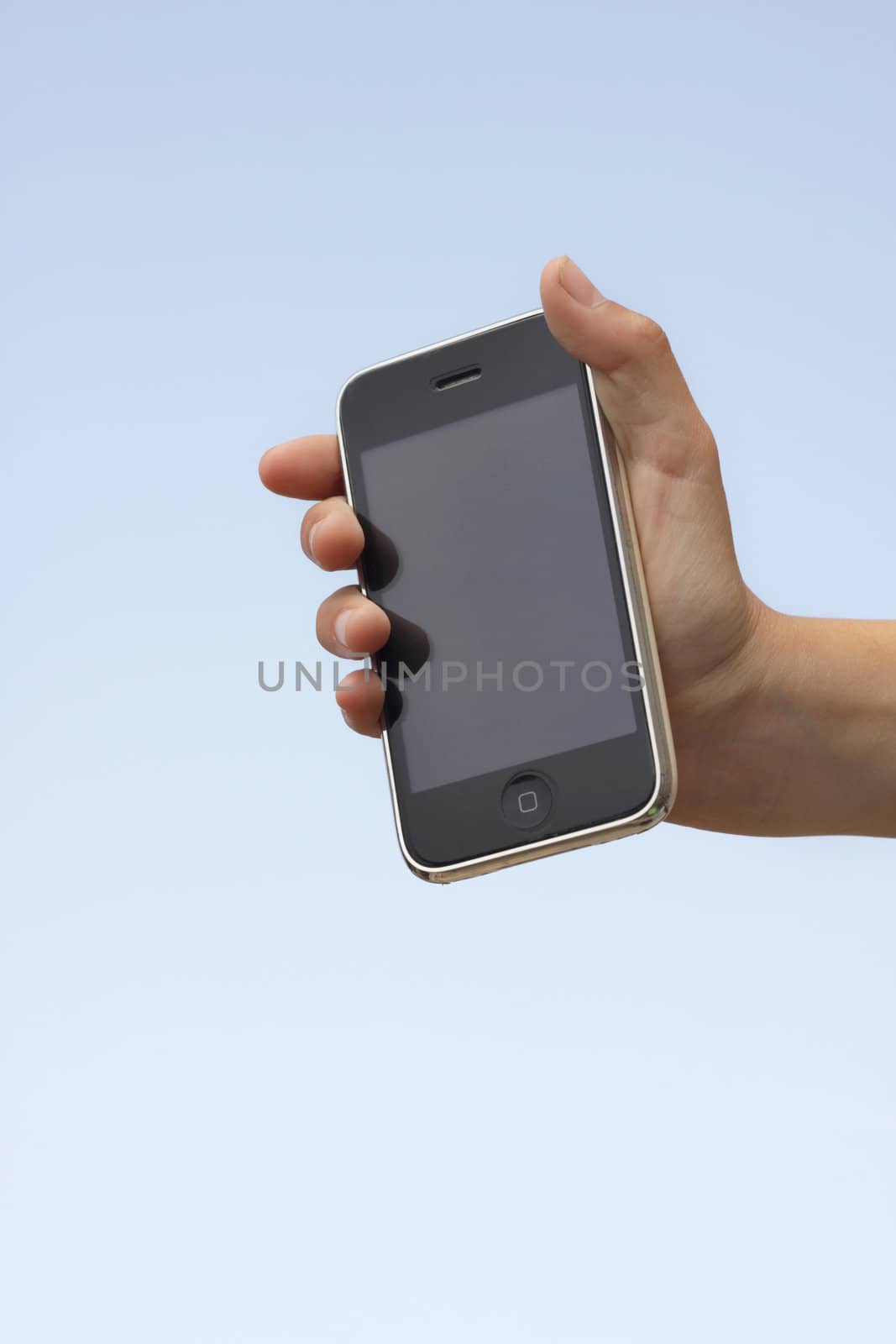 Hand holding up an iphone with a plastic invinsible shield cover towards a blue sky