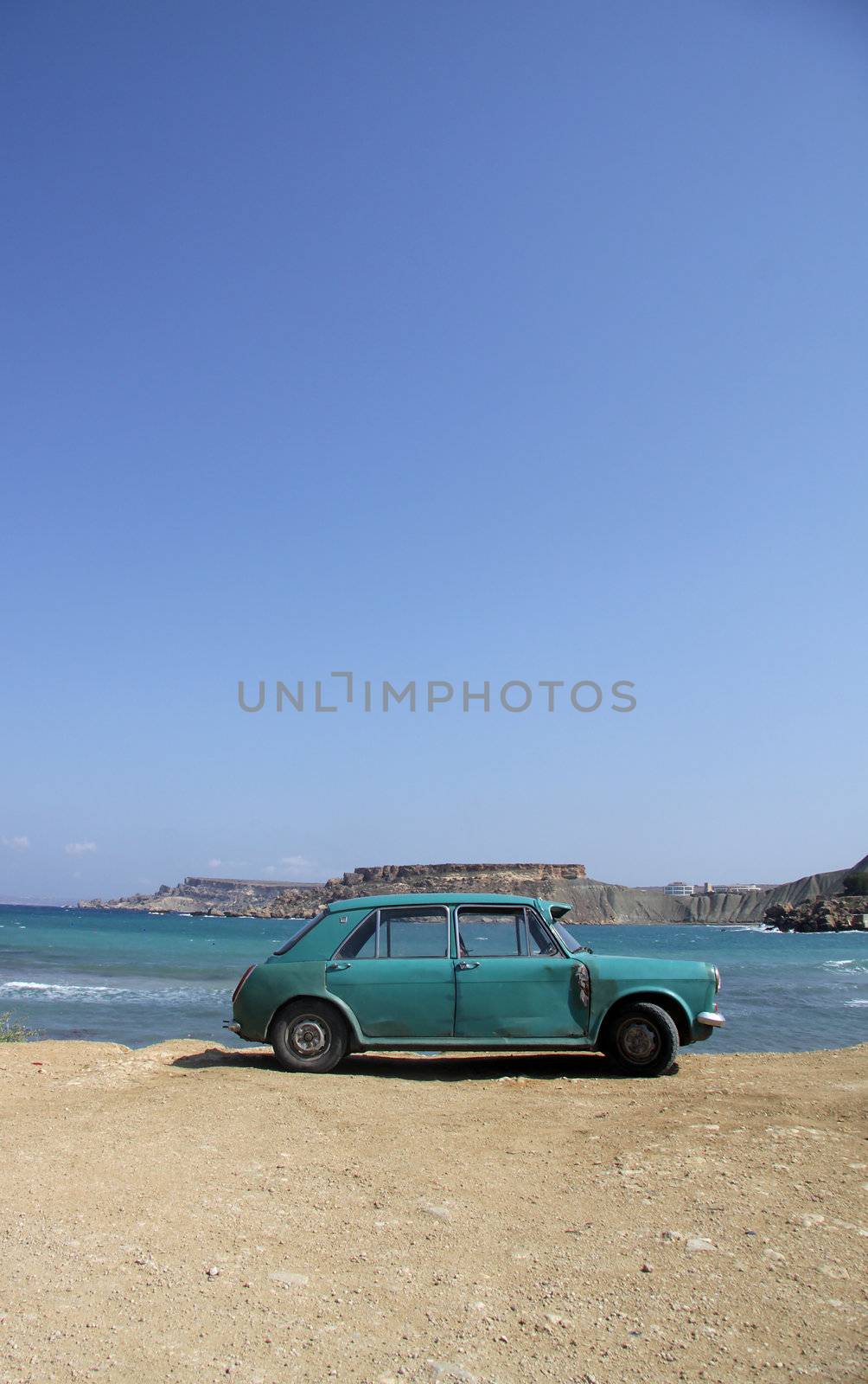 An old rusty car abandoned on a beach by annems