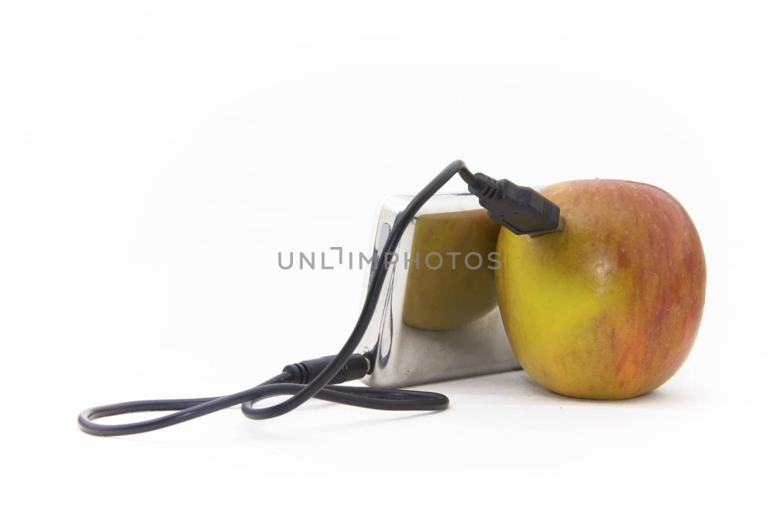 An apple connected to an MP3 player over a wire cable.