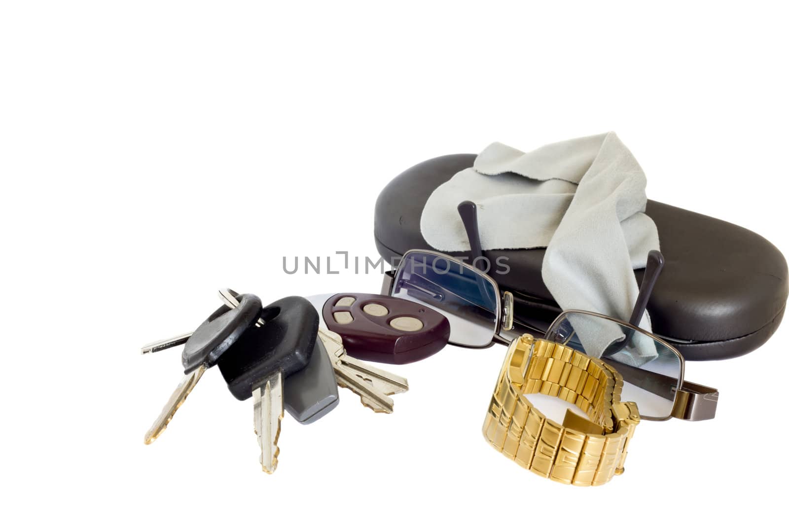 Car keys with an alarm remote next to a pair of glasses, a watch and a case