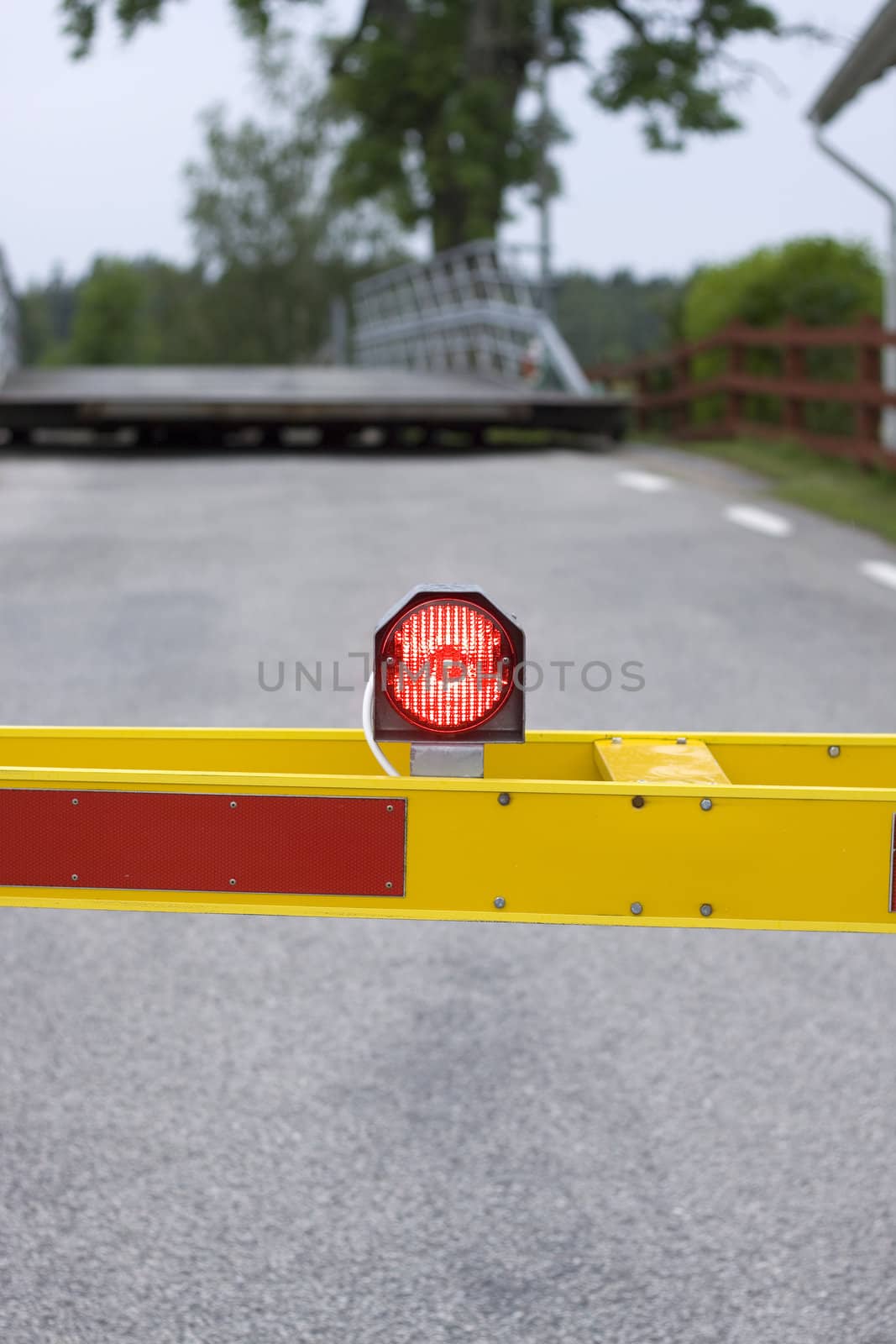 A red flashing light on a road barrier