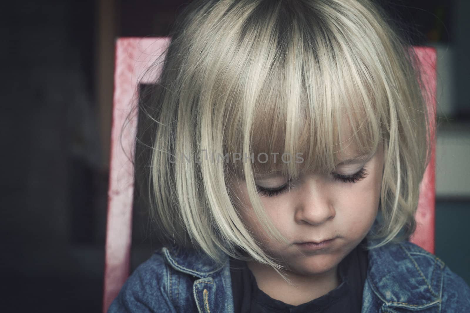 A sad child, not looking at camera