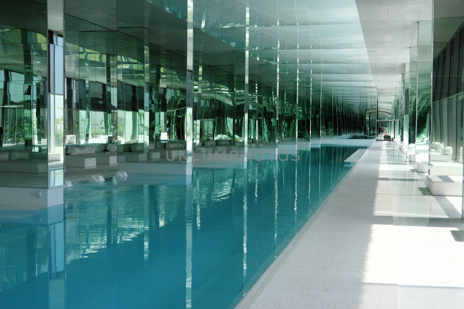 A luxury inside pool in a building with a lot of glasses