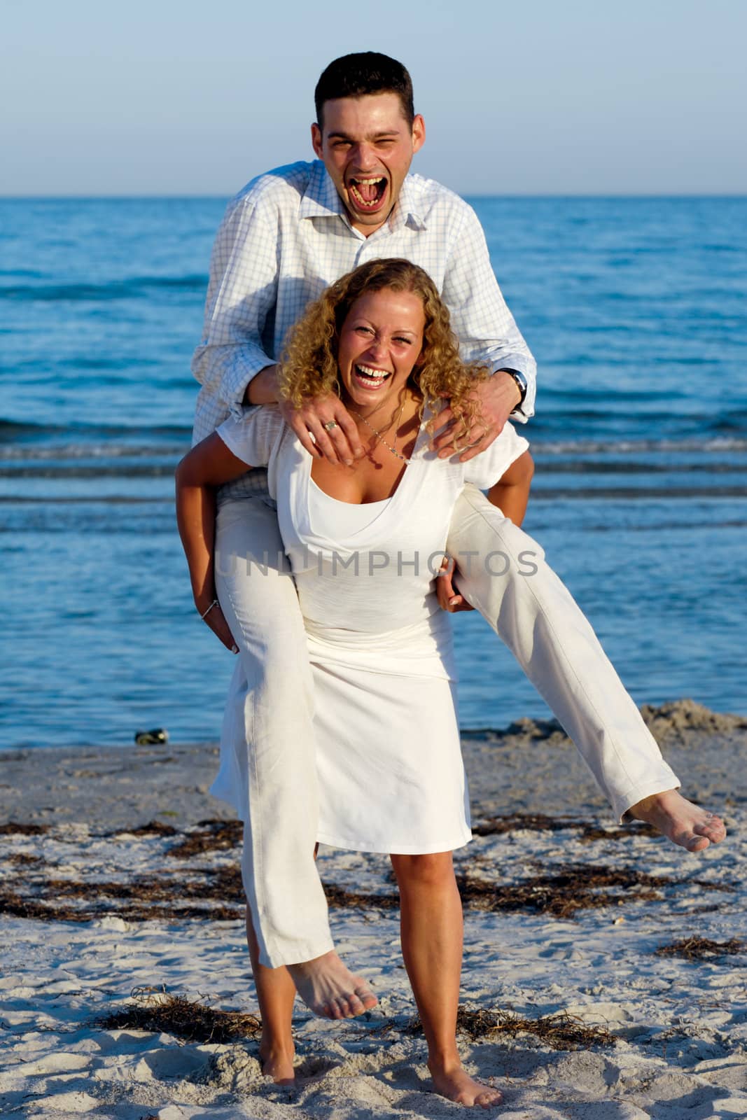 A happy woman and man having fun on beach. 