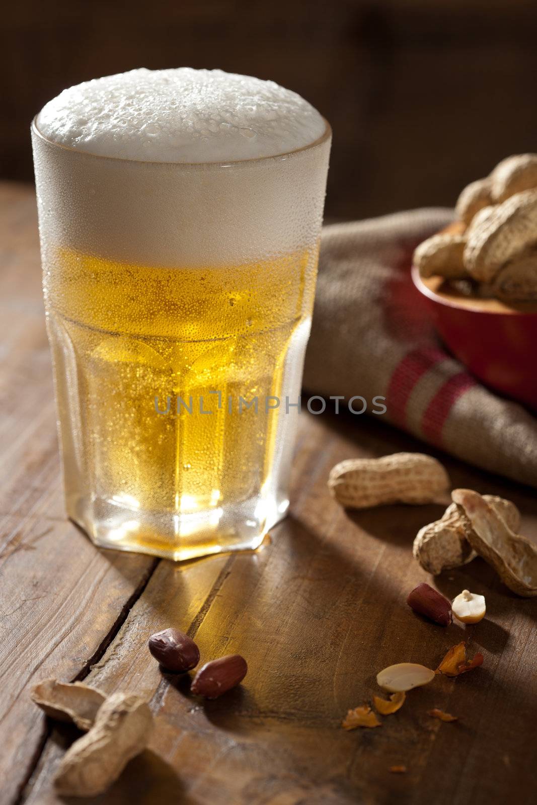 Cool glass of beer with a snack next to it