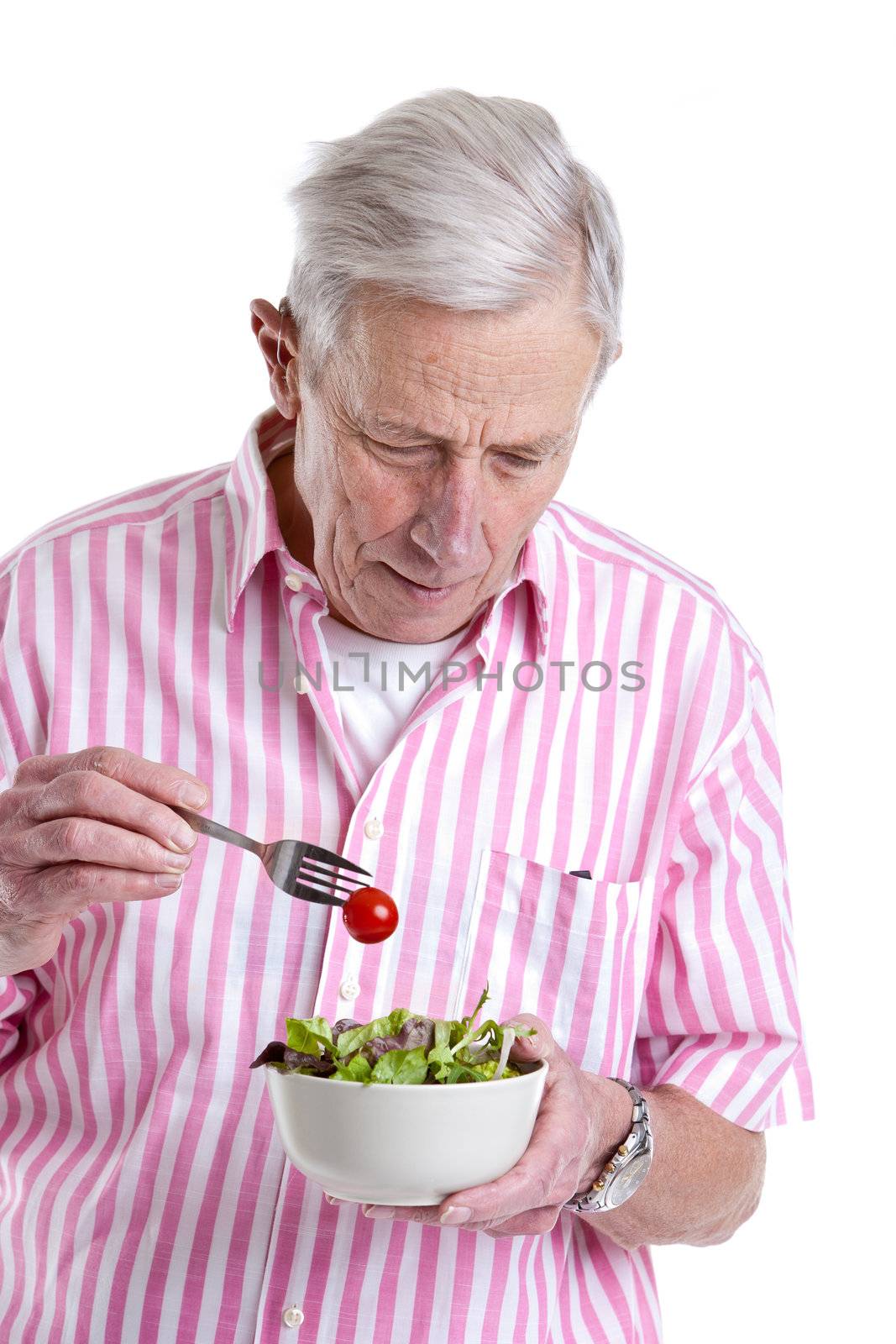 Senior man eating a healthy green salad out of a bowl