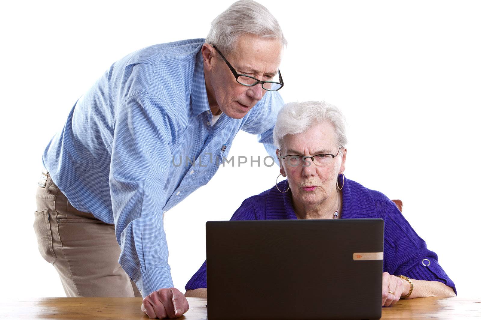 Elderly man and woman behind laptop by Fotosmurf