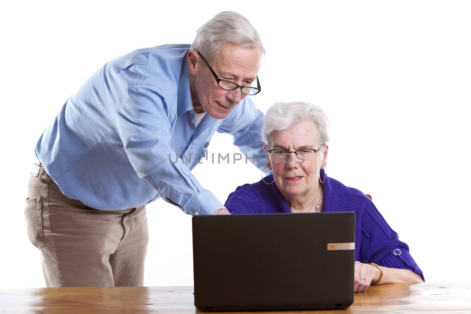 Senior man and woman behind the computer checking things out