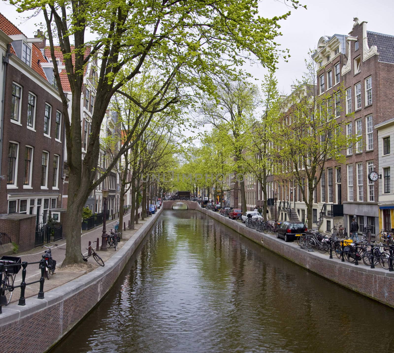 Canal in Amsterdam. Spring cityscape. Bicycles are on the waterfront.