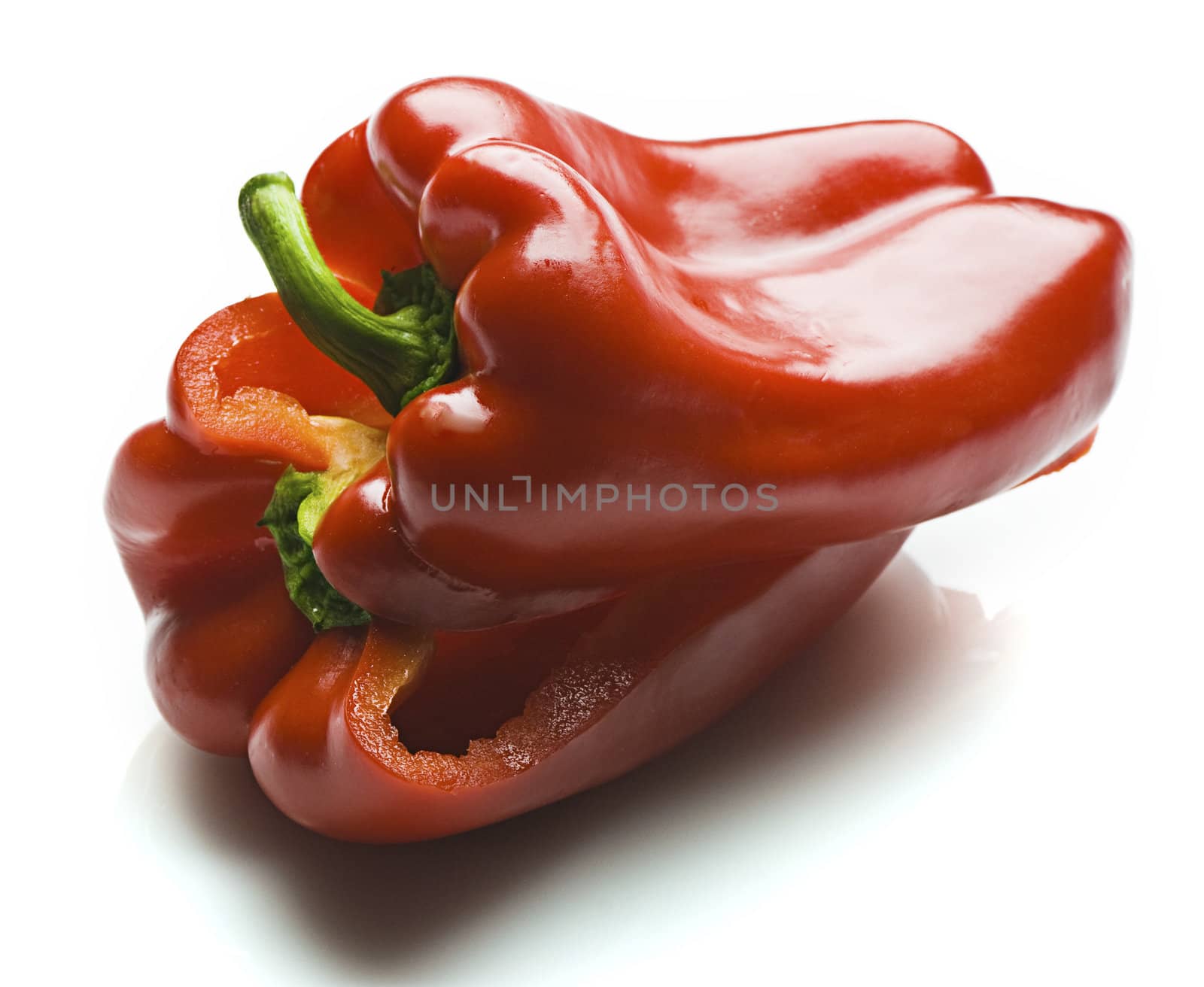 A red capsicum sliced in half and piled on each other. Isolated on white.