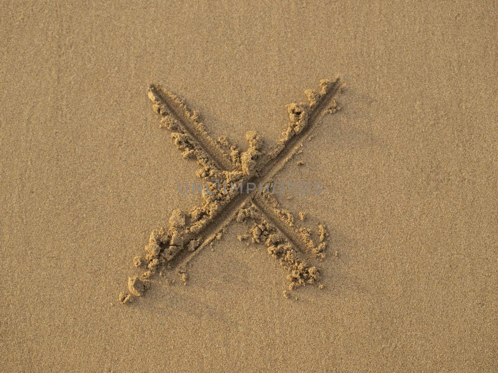 Cross sign drawn on sand by Alminaite