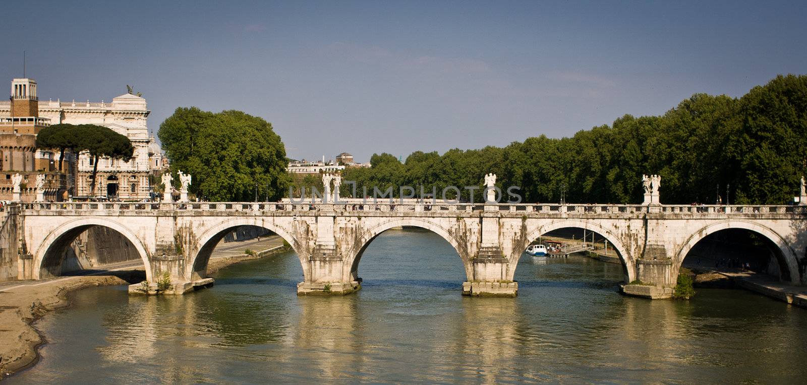 Panoramic side view of the Ponte Sant'Angelo bridge with the river Tiber flowing underneath it - Rome, Italy