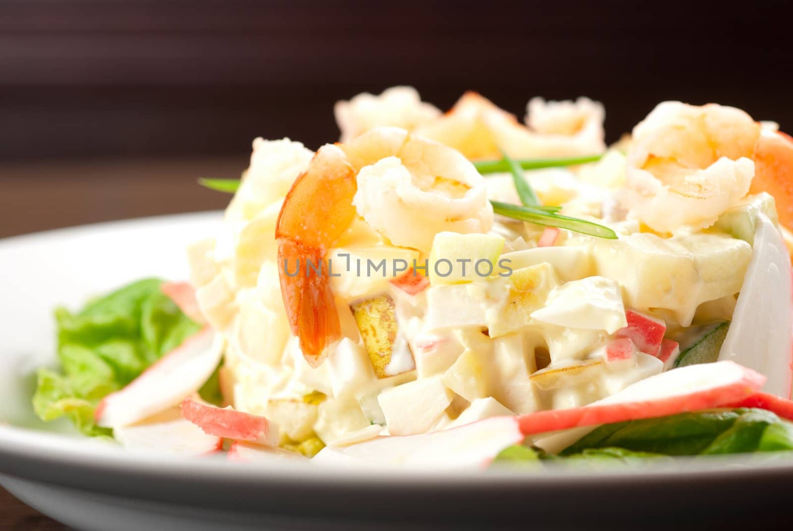 Salad of shrimps, crab meat, cucumbers, apples, potatoes, lettuce, maize, eggs and mayonnaise