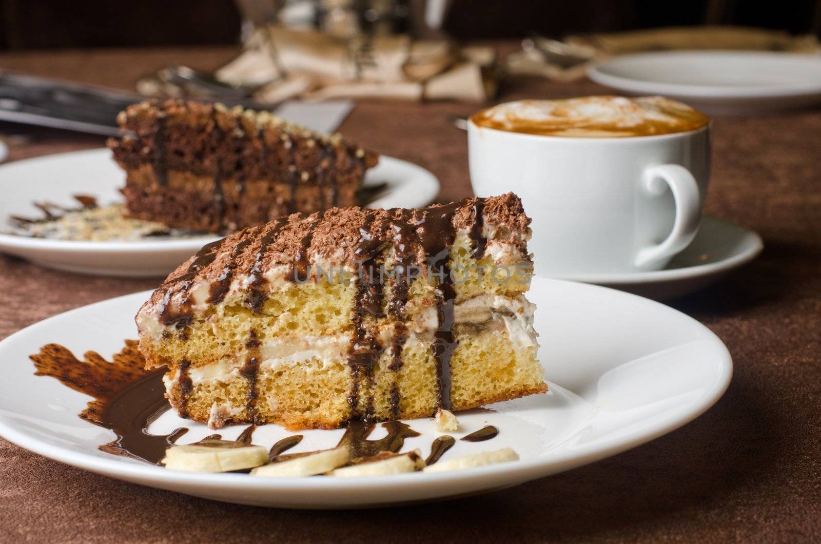 Dessert cakes with banana and coffee at table