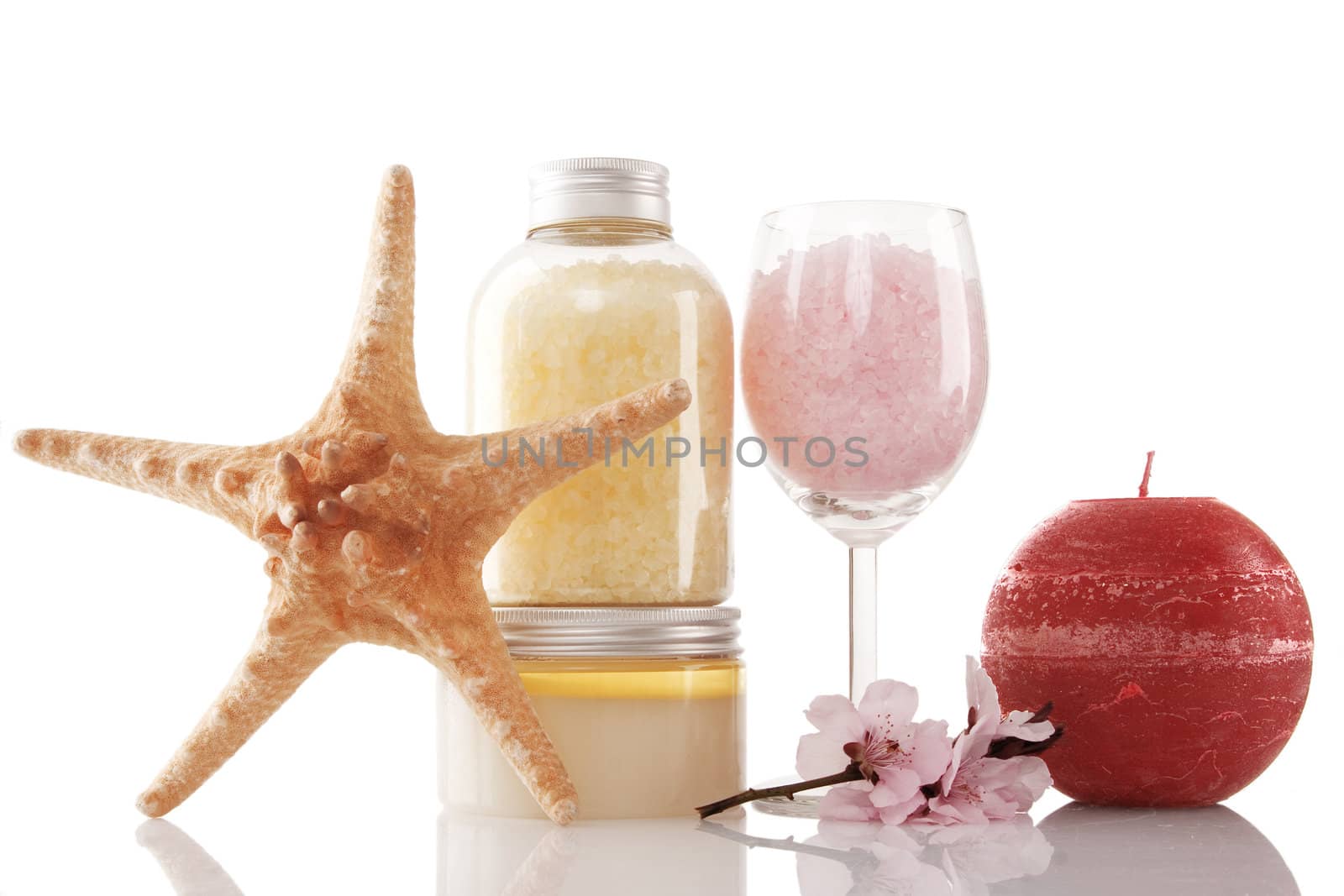 Spa products, candle and cherry flower over white