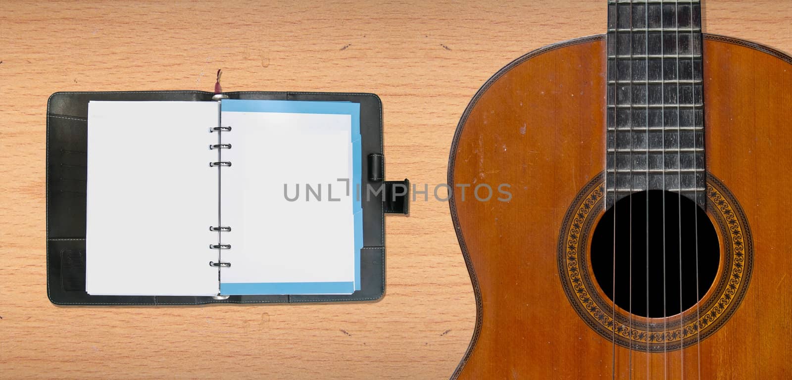Classical guitar with blank leather organizer for your song, schedule, note or etc.