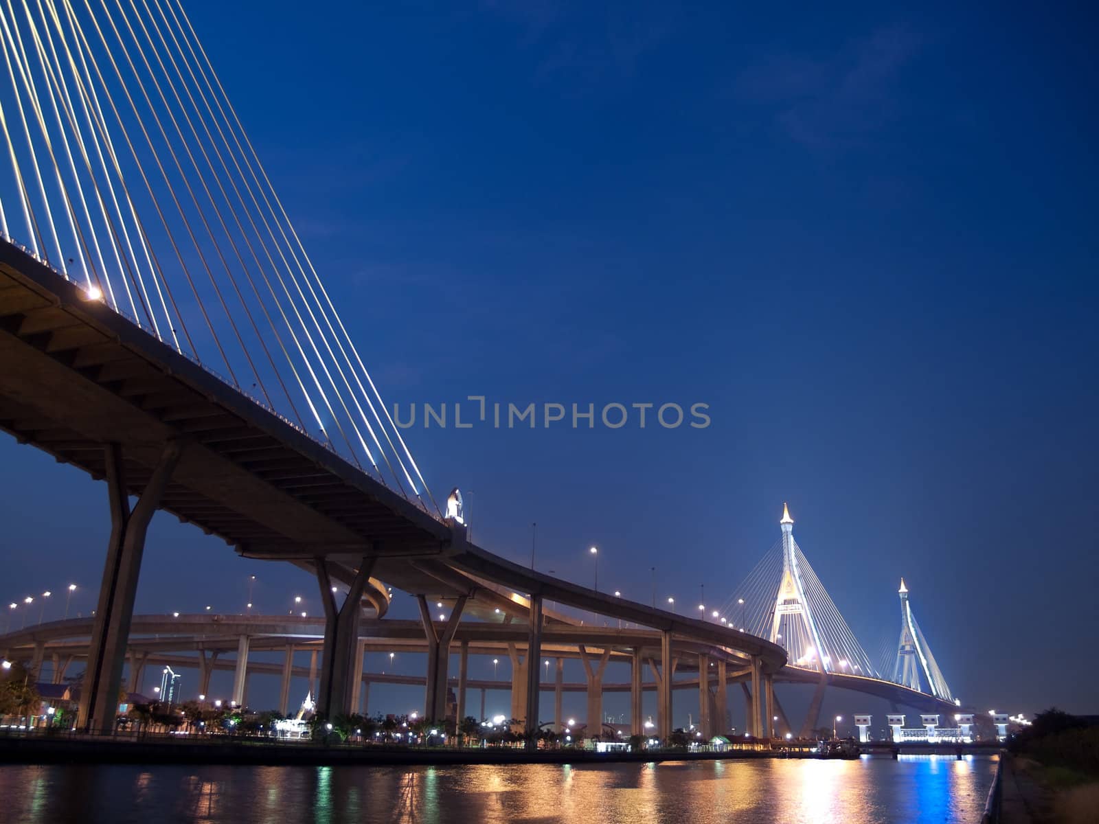 Bhumibol Bridge also casually call as Industrial Ring Road Bridge with floodgate illuminate with spotlight at night scene, Samut Prakarn,Thailand