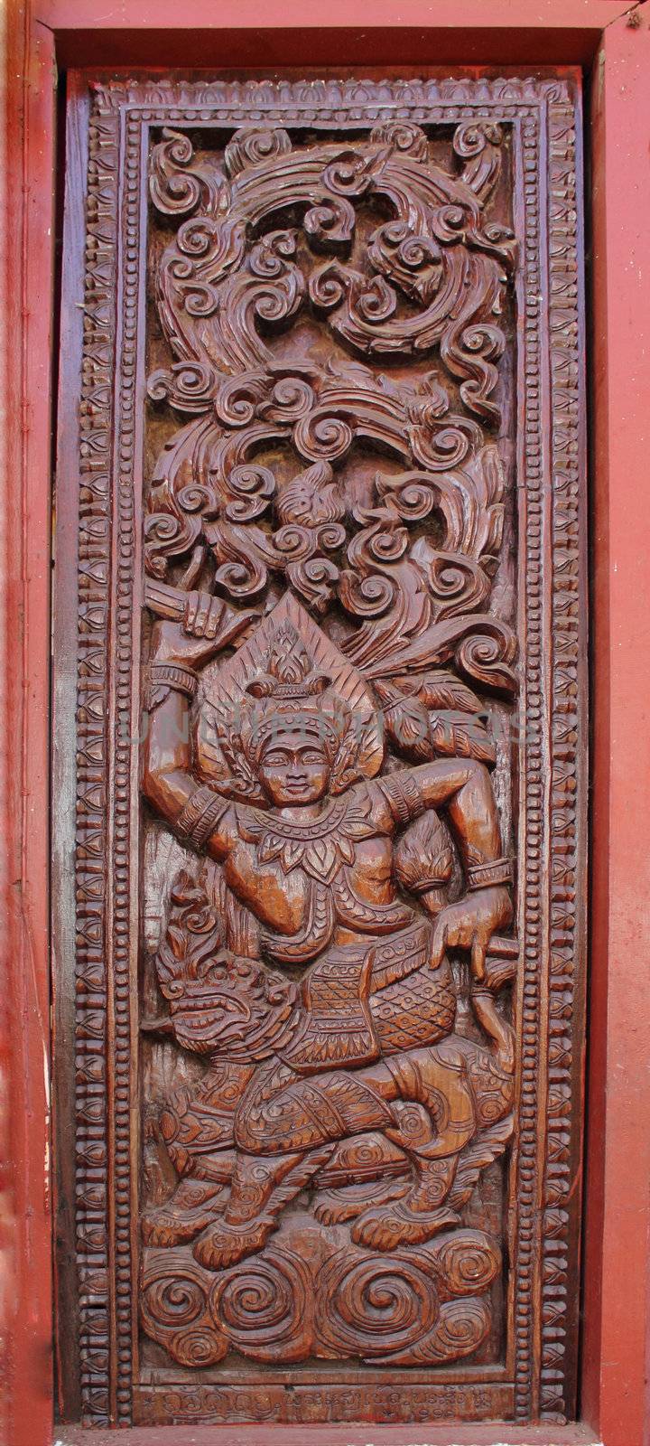 Decorated wooden beside door in Buddhist temple, Laos