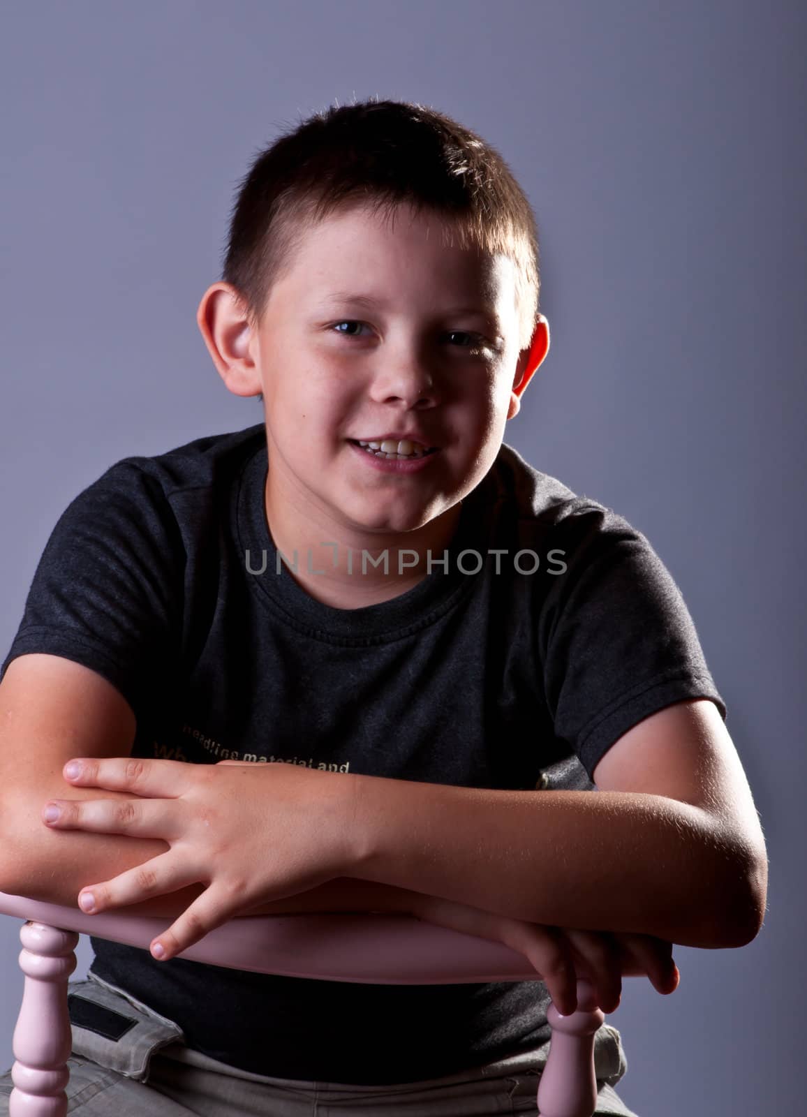 Young boy. Portrait in studio on a grey background.