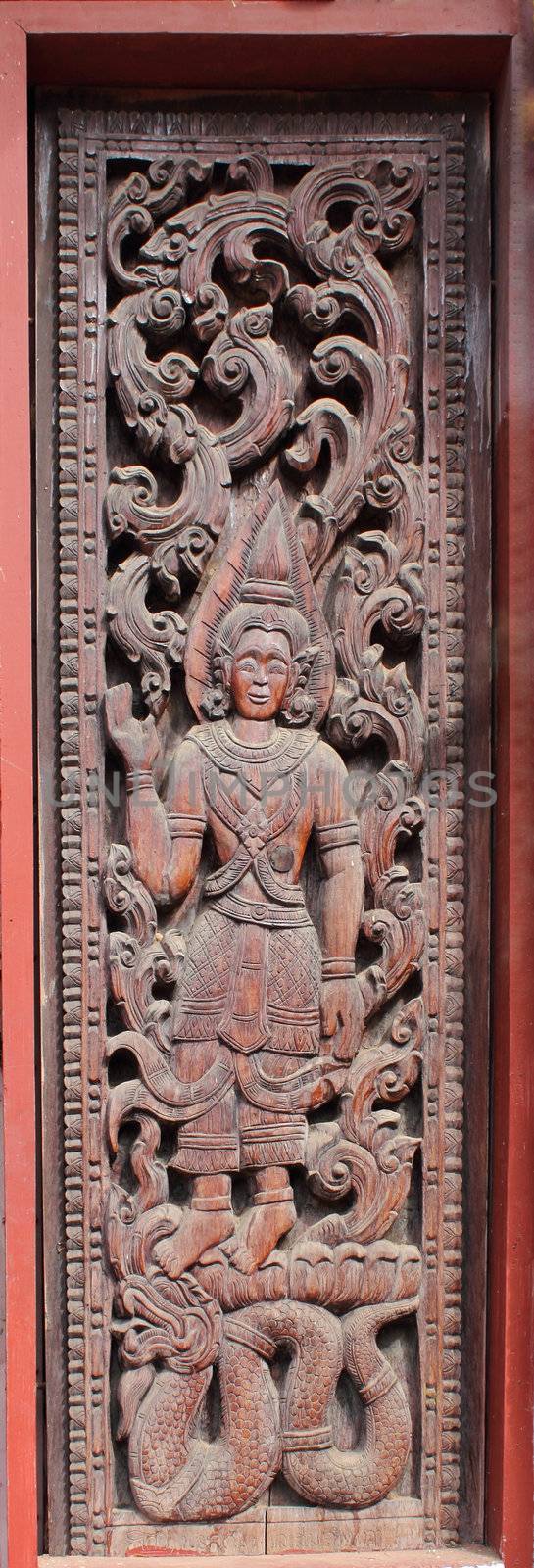 Decorated wooden beside door in Buddhist temple, Laos