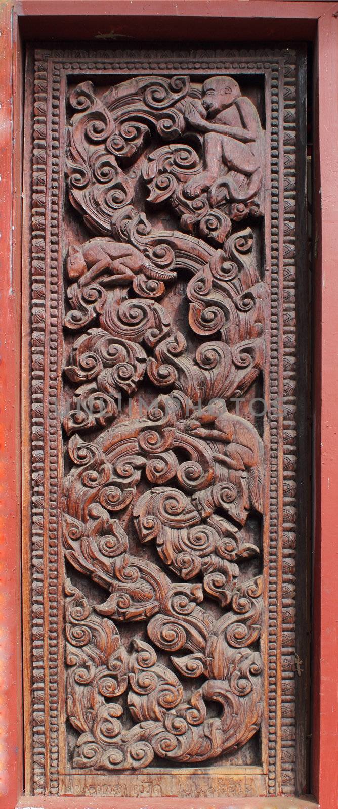Decorated wooden beside door in Buddhist temple, Laos