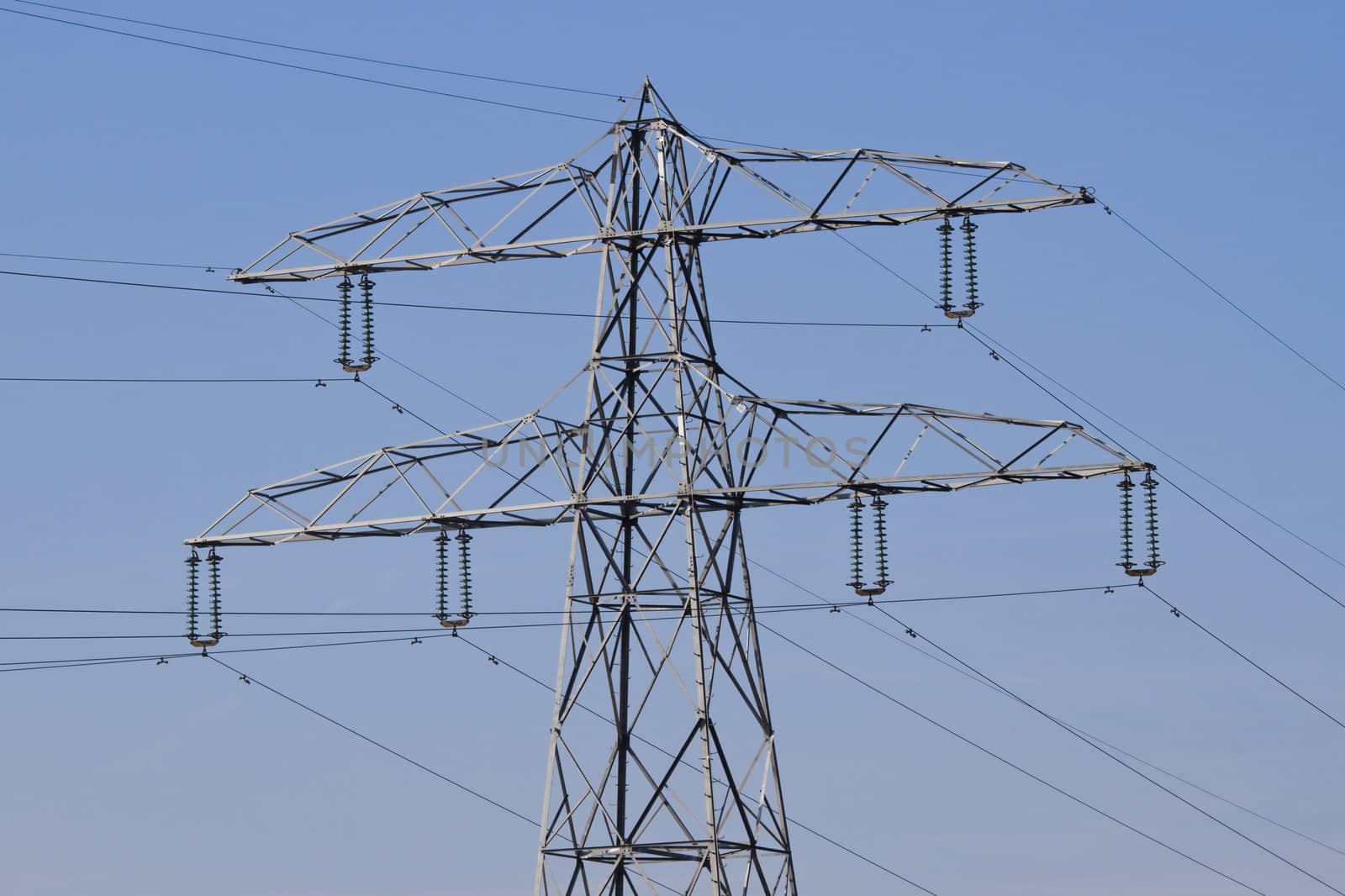 Pylon with electricity wires for energy supply and blue sky background