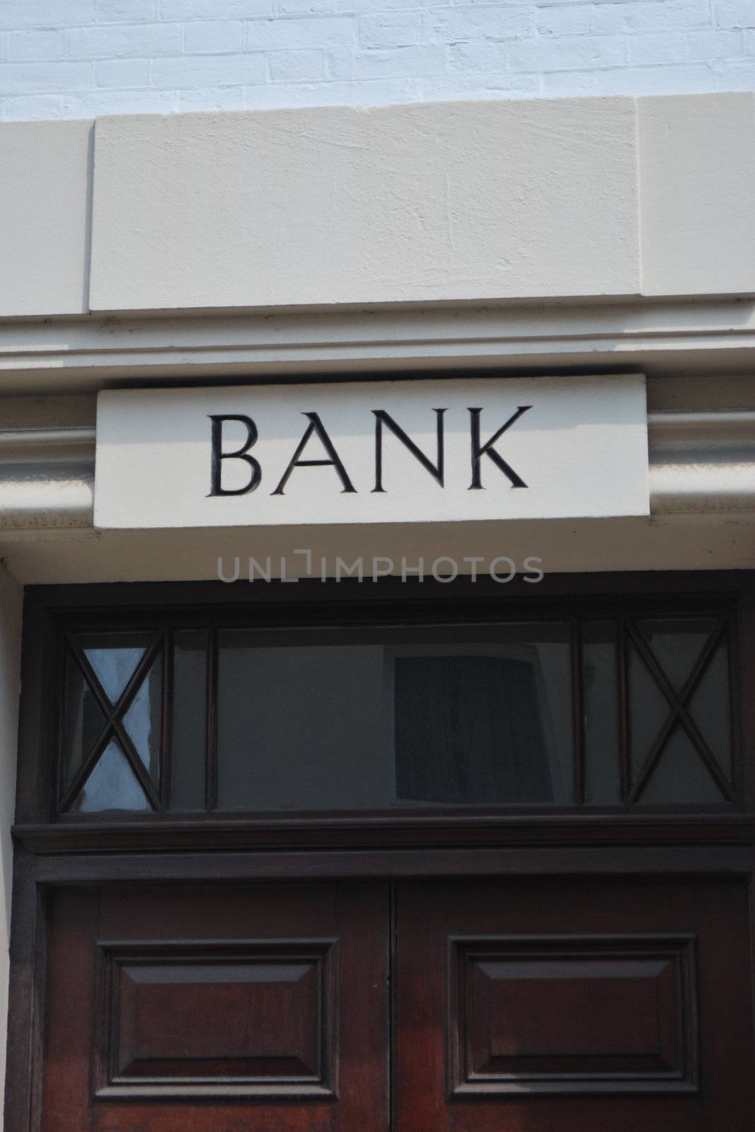 Old fashioned bank door sign in stone