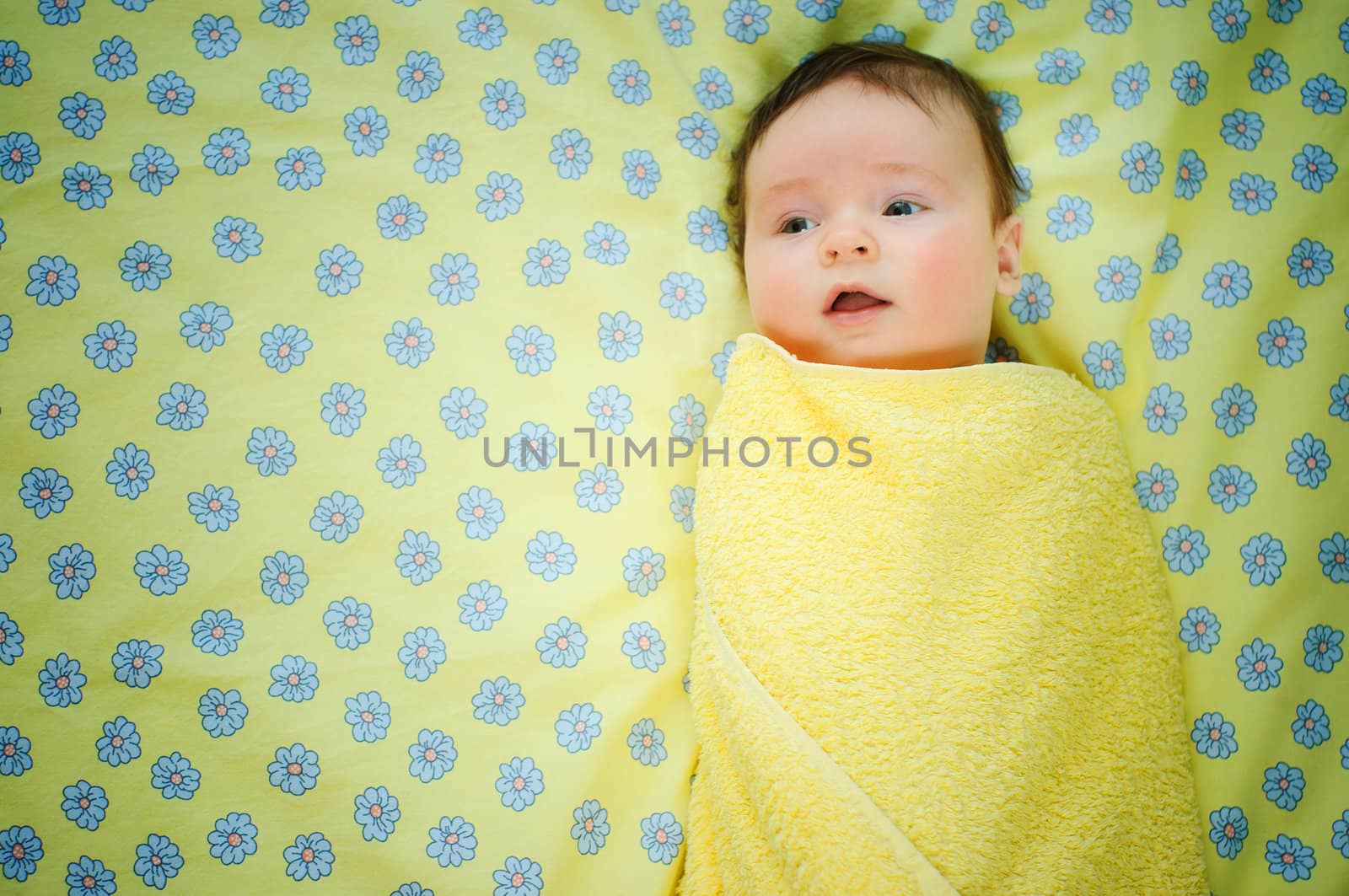 Beautiful baby boy is lying in a bed. by maxoliki