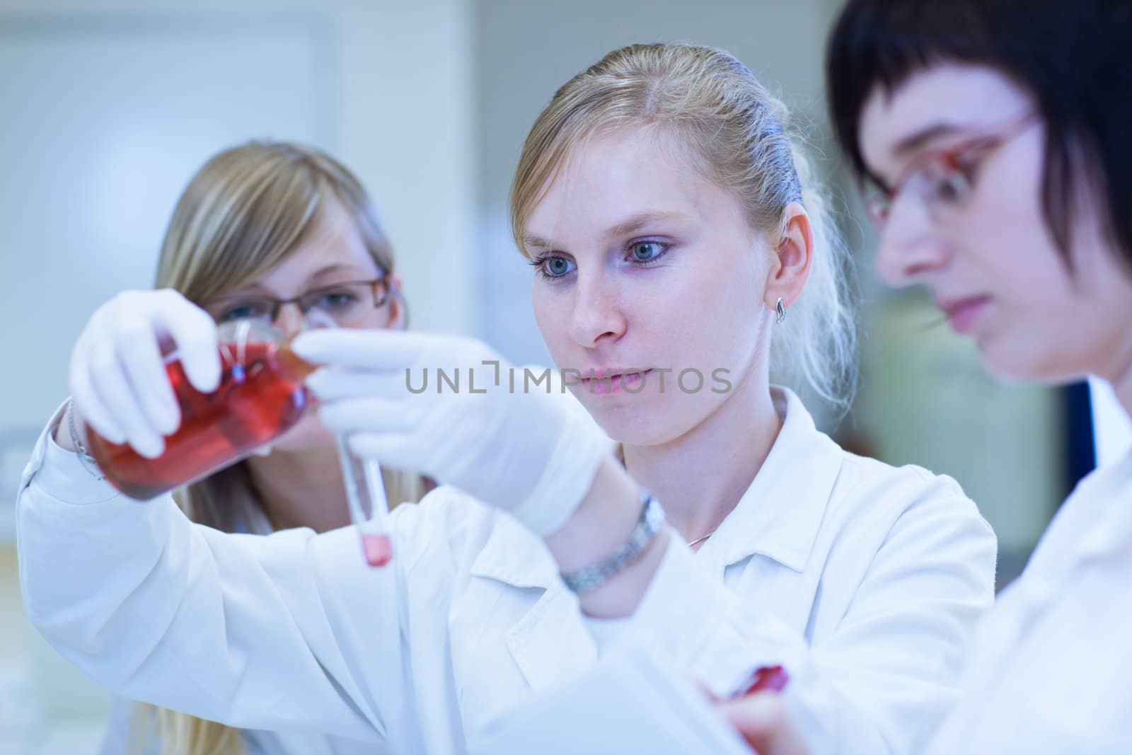 thre female researchers carrying out research in a chemistry lab (color toned image; shallow DOF)
