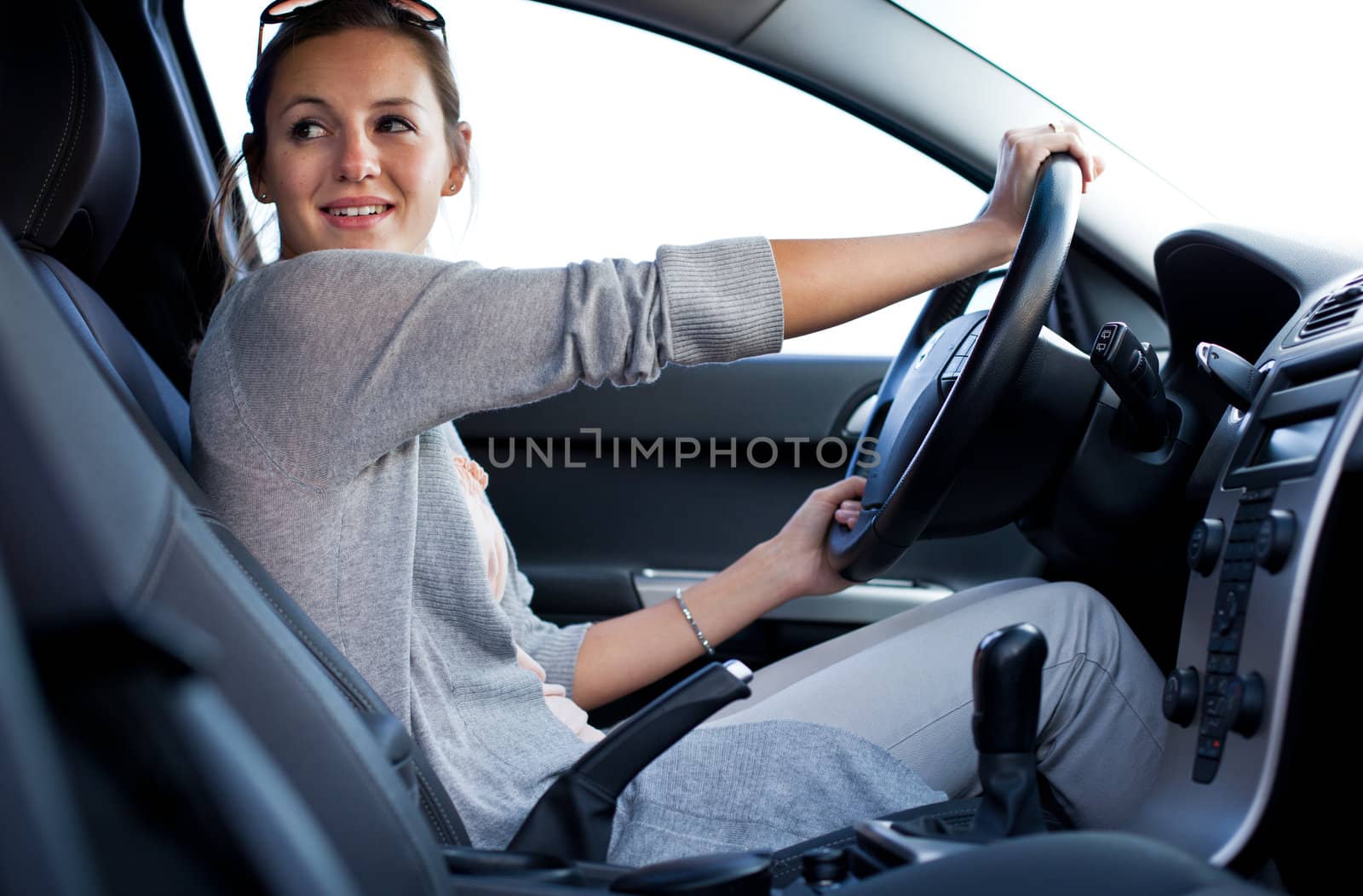 Pretty young woman driving her new car