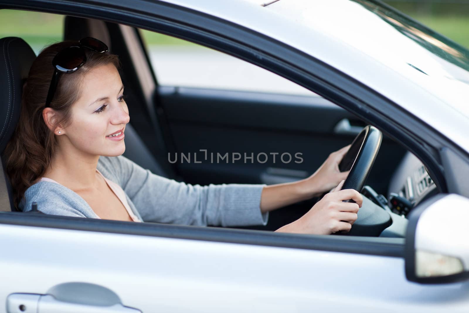 Pretty young woman driving her new car