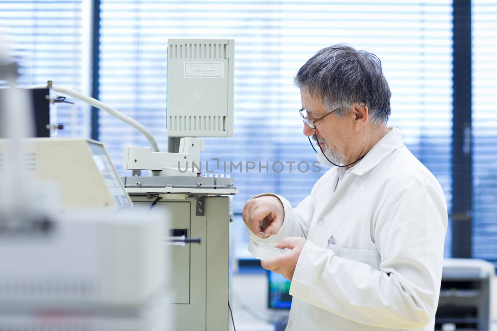 senior male researcher carrying out scientific research in a lab (shallow DOF; color toned image)