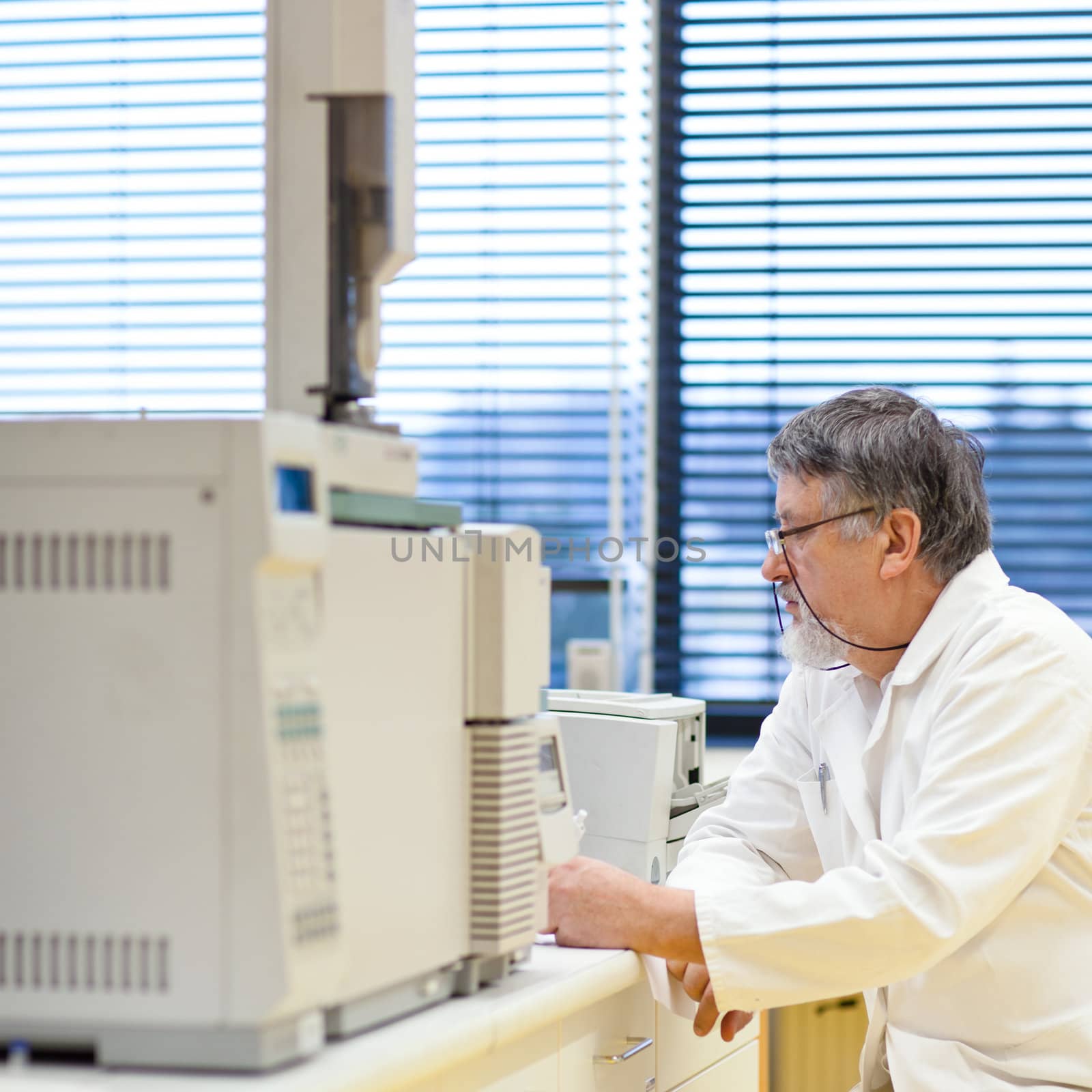 senior male researcher carrying out scientific research in a lab (shallow DOF; color toned image)