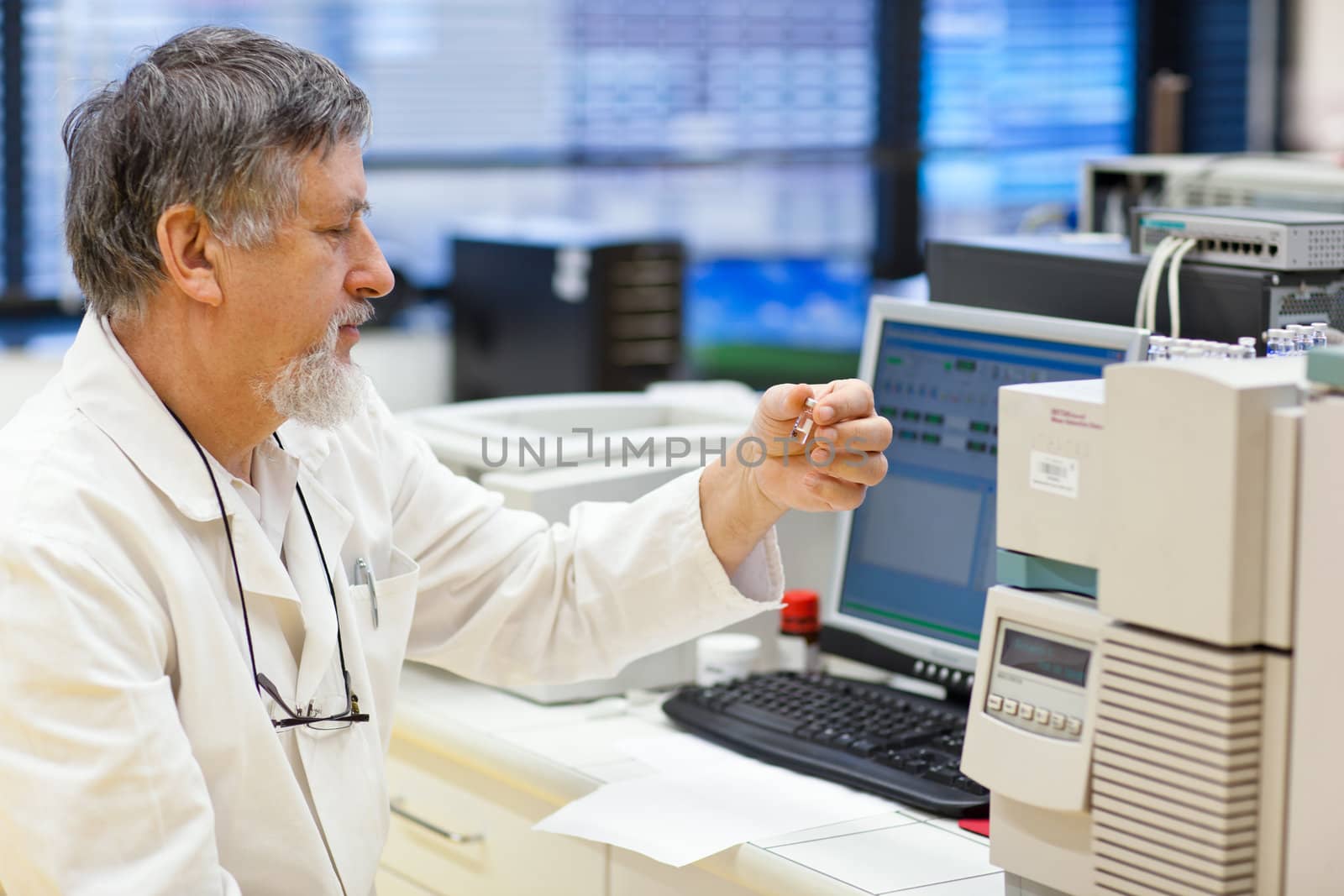 senior male researcher carrying out scientific research in a lab (shallow DOF; color toned image)