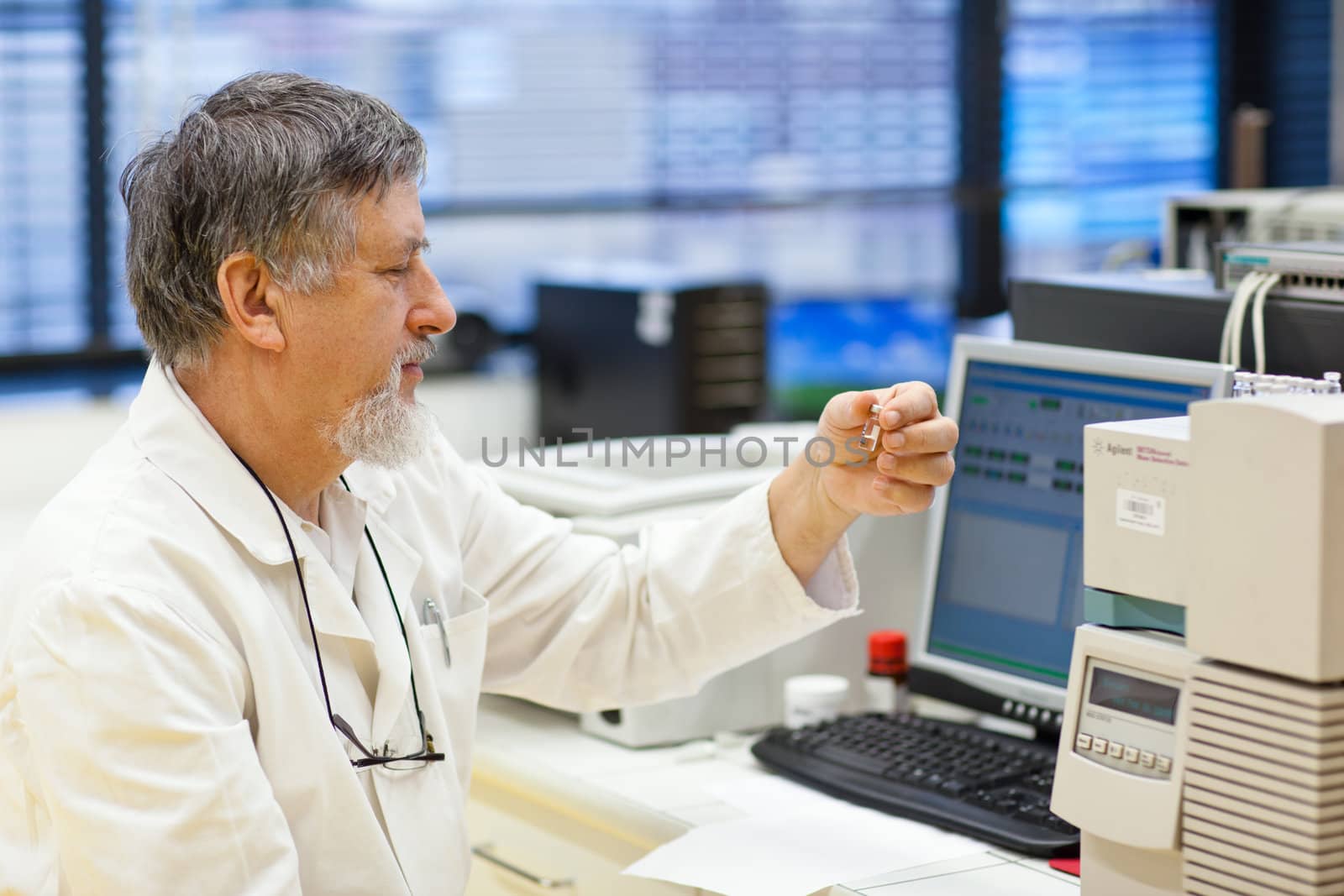 senior male researcher carrying out scientific research in a lab (shallow DOF; color toned image)