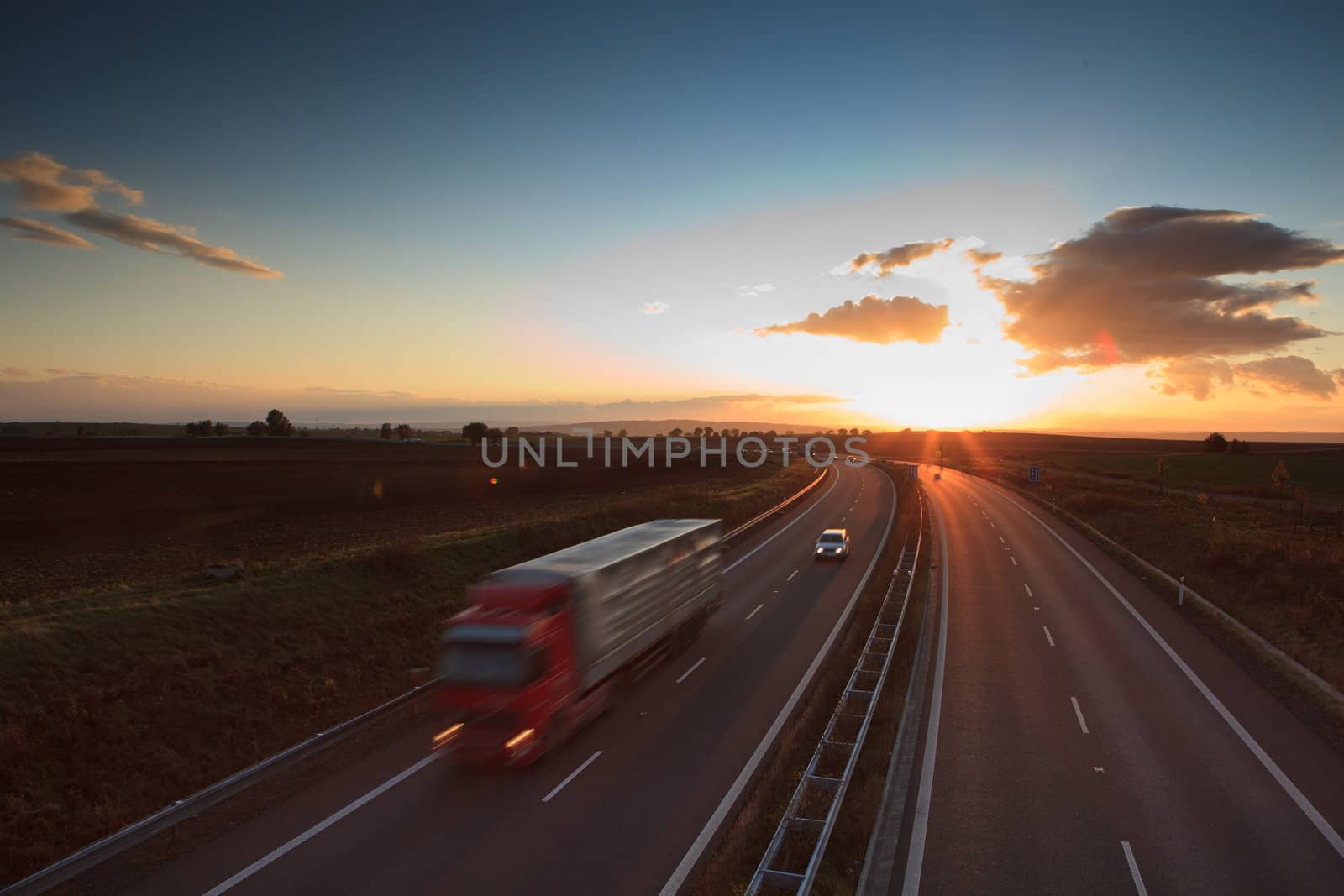 highway traffic - motion blurred truck on a highway/motorway/speedway at dusk (color toned image)