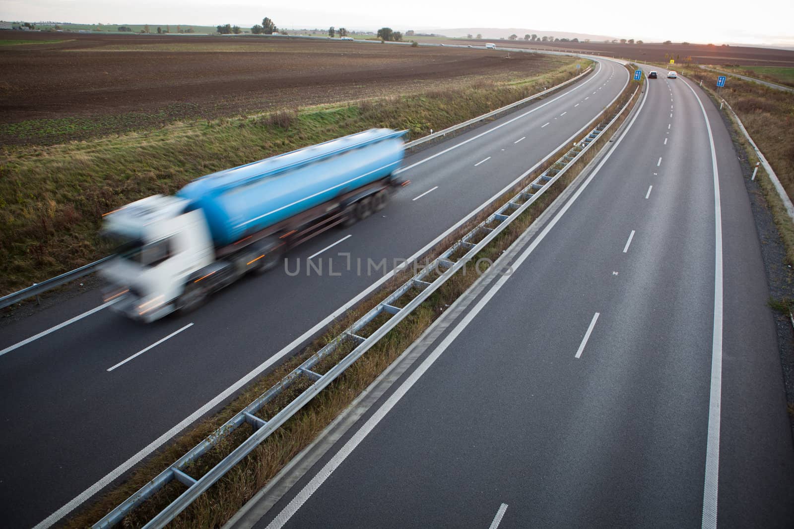 highway traffic - motion blurred truck on a highway/motorway/speedway at dusk (color toned image)