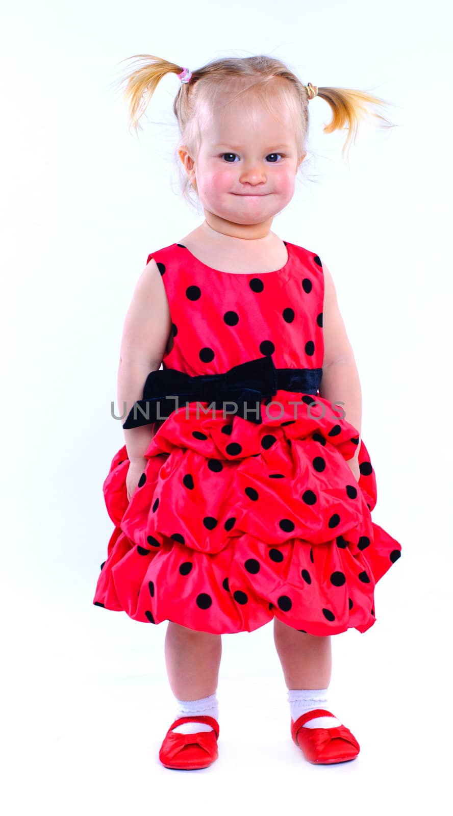 Cute little baby girl in a red dress. In the studio. Isolated
