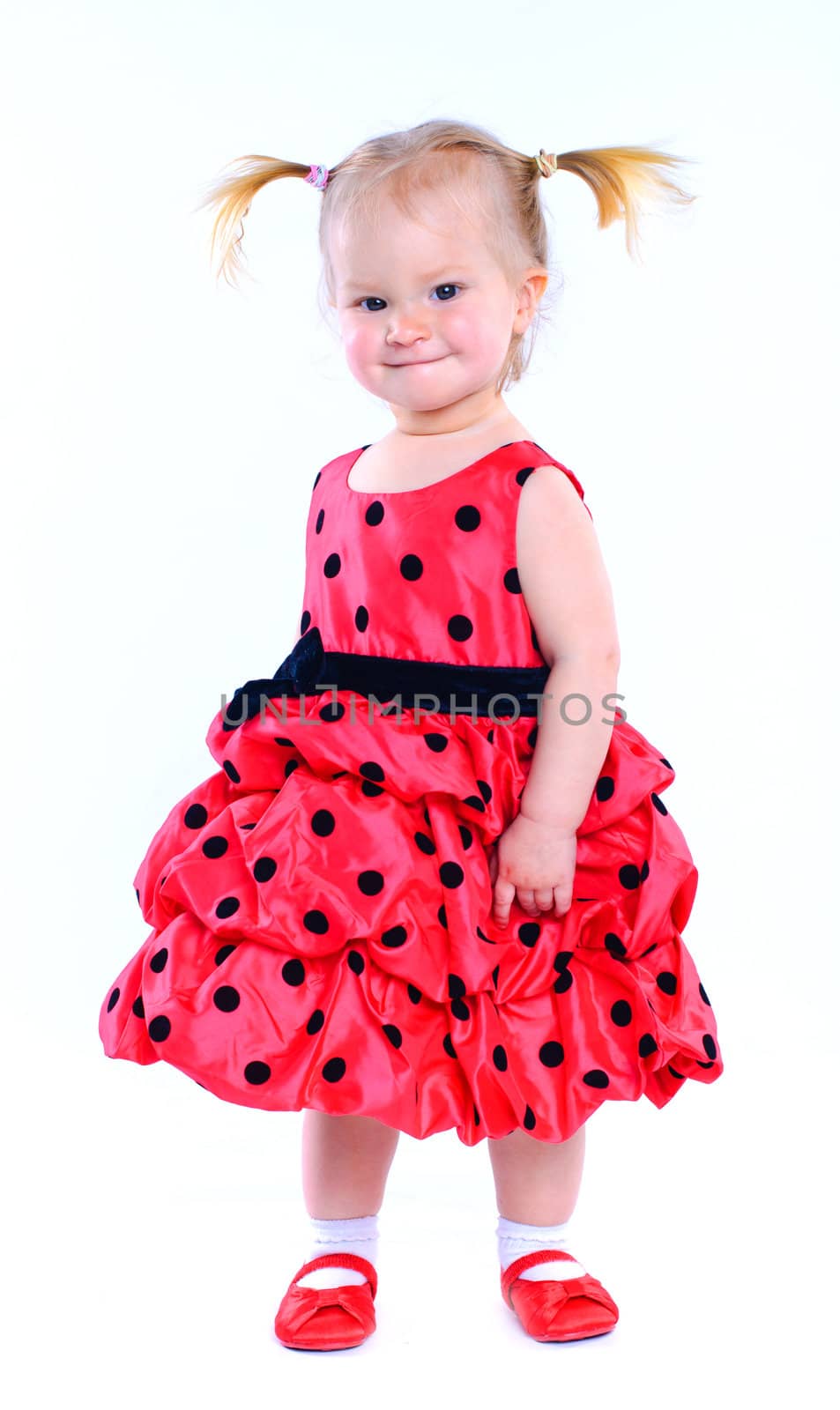 Cute little baby girl in a red dress. In the studio. Isolated